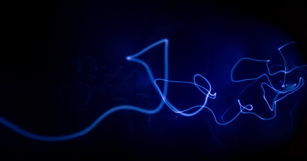 Blue arcing light trails against a black background
